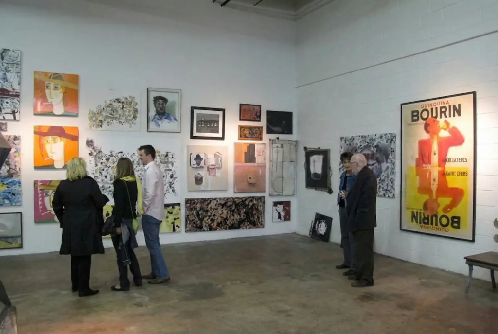 Visitors viewing Christian Valverde's abstract painting at Art Bidz Gallery auction event