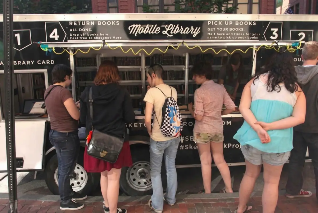 Visitors lined up to view artwork at Brooklyn Art Library mobile exhibition featuring Christian Valverde