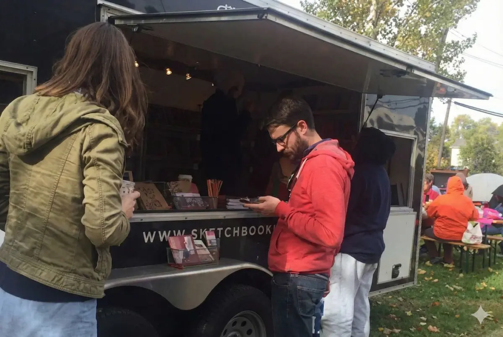 Visitor viewing Christian Valverde's sketchbook at Brooklyn Art Library mobile exhibition in New York